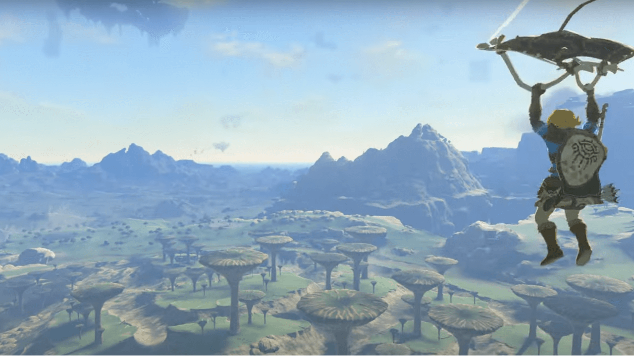 gameplay photo of Link from the Legend of Zelda: Tears of the Kingdom paragliding over a grove of trees with mountains in the background and open sky